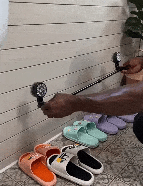 Installing a wall-mounted bathroom rack above several pairs of slippers