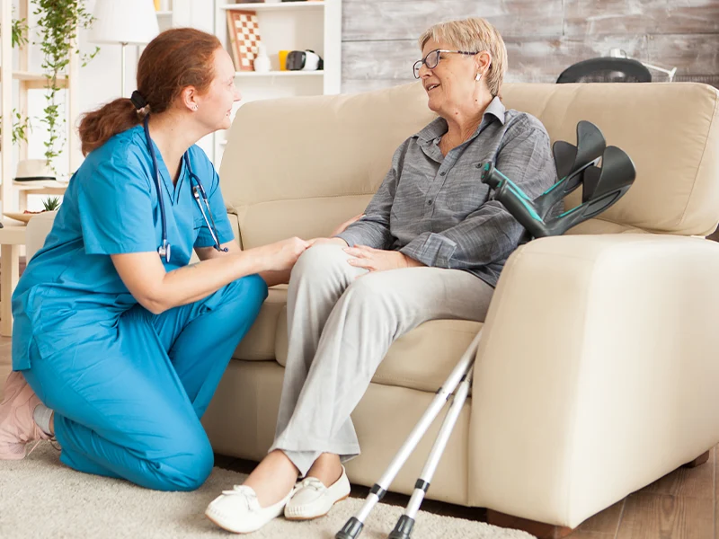 An older adult speaking with a caregiver at home